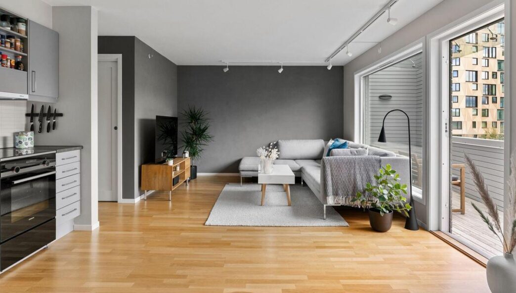 Descubra un cómodo espacio de residencia premium en CDMX: amplia sala de estar de concepto abierto, finamente diseñada con pisos de madera clara que realzan la luminosidad y amplitud del ambiente. El mobiliario contemporáneo incluye un elegante sofá gris y una mesa central minimalista, complementados por ventanas panorámicas que brindan acceso directo a un exclusivo balcón privado. Detalles decorativos como plantas interiores aportan frescura, mientras la moderna televisión empotrada marca el tono tecnológico del inmueble. La cocina integral, equipada con gabinetes en tonos grises mate, se integra visualmente para ofrecer funcionalidad y diseño superior—atributos ideales para inversionistas o compradores exigentes en busca de plusvalía y estilo urbano incomparable.