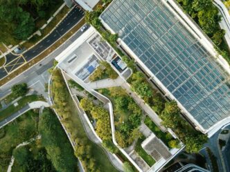 Vista aérea de REBS Tulum, un exclusivo desarrollo urbano que destaca por su arquitectura contemporánea, techos de cristal y terrazas ajardinadas. Rodeado de exuberante vegetación y con accesos viales inmediatos, este inmueble premium ofrece conectividad estratégica y diseño cómodo, ideales para inversionistas o compradores que valoran espacios únicos en una ubicación privilegiada.
