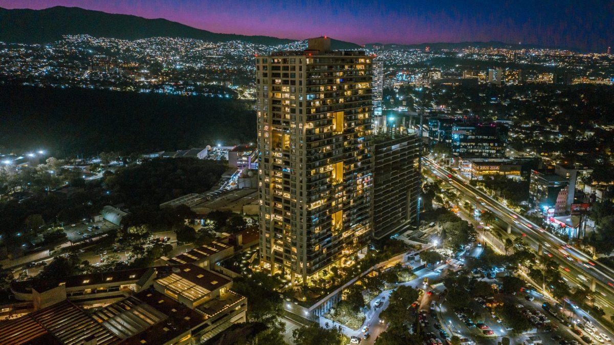 Origina Pedregal se erige como un ícono de arquitectura contemporánea en el corazón de la ciudad, destacando por su impresionante altura y diseño vanguardista. Esta exclusiva torre residencial, realzada cada noche por una sofisticada iluminación, domina el panorama urbano rodeado de vibrantes luces citadinas y principales vías de acceso. Desde sus residencias, los propietarios disfrutan vistas inigualables hacia la majestuosa silueta montañosa bajo cielos intensamente azules y púrpuras, lo que convierte a Origina Pedregal en una propuesta inmobiliaria única para quienes buscan exclusividad, lujo y valor patrimonial sostenido.