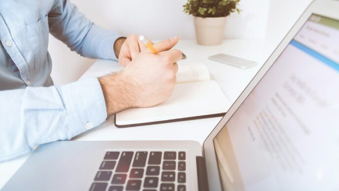 Un inversionista, vestido con una camisa azul claro, analiza detenidamente información clave en un escritorio minimalista y elegante. Frente a él, una computadora portátil abierta exhibe la plataforma Inmobot, herramienta líder en el sector inmobiliario premium para la gestión de oportunidades exclusivas. Junto a la tecnología de punta utilizada en el proceso de toma de decisión—smartphone y materiales cuidadosamente dispuestos—destaca el ambiente cómodo y eficiente que caracteriza a quienes apuestan por inversiones inmobiliarias de alto valor agregado.