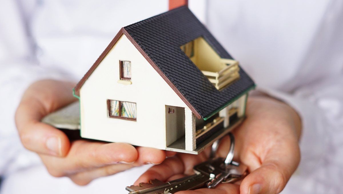 Una persona sostiene una maqueta exclusiva de vivienda junto a un juego de llaves, simbolizando la adquisición o alquiler de inmuebles en un contexto dinámico del mercado residencial. La escena transmite oportunidades excepcionales en el sector inmobiliario premium, donde cada detalle marca la diferencia para inversores y compradores exigentes que buscan propiedad con alto valor agregado. El fondo desenfocado enfatiza el protagonismo del inmueble y la experiencia personalizada que distingue a las mejores inversiones patrimoniales.
