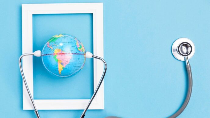 Un globo terráqueo en miniatura, delicadamente sostenido por un estetoscopio dentro de un marco blanco rectangular, destaca sobre un fondo azul claro. Esta imagen representa la visión global y el cuidado minucioso que definen a las inversiones inmobiliarias premium: seguridad, precisión y alcance internacional para satisfacer las expectativas de los compradores más exigentes.