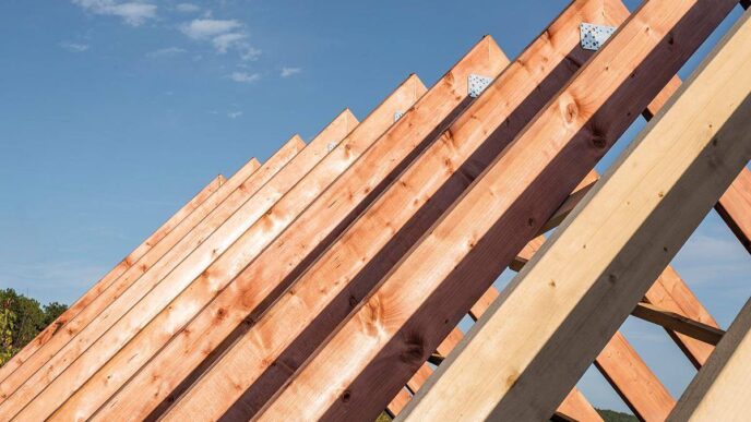 Vista detallada de las cerchas de madera bajo construcción, enmarcadas contra un cielo despejado. Las vigas—perfectamente alineadas y aseguradas con placas metálicas—evidencian prácticas constructivas sostenibles y duraderas. Esta meticulosa atención a la calidad estructural garantiza una inversión segura y atractiva para quienes buscan excelencia arquitectónica en el mercado inmobiliario premium.