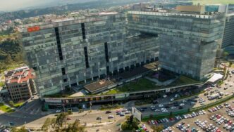 Vista aérea de un exclusivo complejo corporativo compuesto por edificios modernos de cristal y patio central, estratégicamente ubicado sobre una avenida principal con acceso inmediato a estacionamientos y servicios. Su diseño interconectado es resultado de 14 años de experiencia consolidada en el sector FIBRA en México, ofreciendo activos operativos que cumplen con los más altos estándares para inversionistas y compradores que buscan excelencia, rentabilidad y plusvalía en bienes raíces premium.