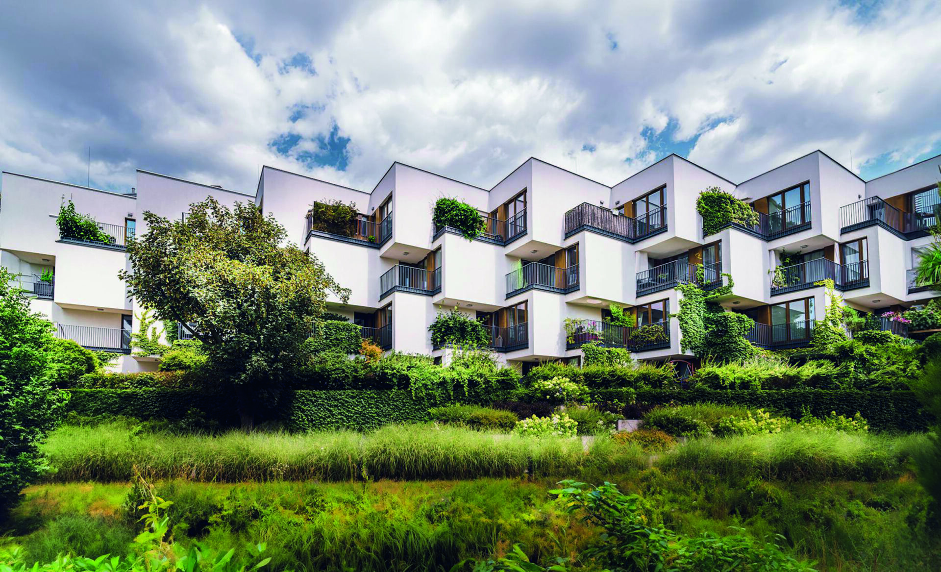 Exclusivo edificio residencial de arquitectura moderna, caracterizado por su elegante fachada blanca y atractivos balcones geométricos que integran vegetación y plantas, creando un entorno natural dentro del espacio privado. Este desarrollo inmobiliario premium cuenta con certificación LEED, garantizando altos estándares de eficiencia energética y sostenibilidad. Rodeado de jardines exuberantes y amplias áreas verdes, la propiedad destaca como una oportunidad incomparable para inversionistas o compradores que valoran el diseño contemporáneo, la exclusividad y el compromiso ambiental en una ubicación privilegiada.