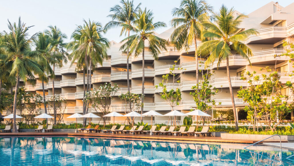 Una piscina exclusiva, rodeada de elegantes tumbonas y sombrillas, se ubica frente a un hotel de varios niveles rodeado de palmeras y exuberantes jardines. Esta propiedad premium encarna el cómodo estilo de vida de Los Cabos, fusionando lujo, privacidad y un entorno natural incomparable; una oportunidad excepcional para inversores o compradores que buscan acceder al dinámico mercado inmobiliario turístico de alta gama.