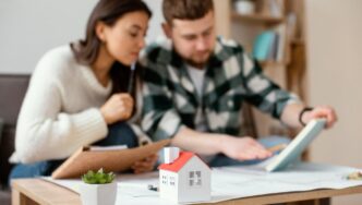 Una mujer y un hombre se reúnen en una mesa en México analizando cuidadosamente documentación relevante y notas estratégicas. Al frente, un modelo arquitectónico de vivienda premium y una planta ornamental destacan el enfoque de la conversación: la evaluación del valor inmobiliario y la revisión de documentos clave, posiblemente relacionados con INBAPREVI. Este escenario refleja el compromiso con procesos rigurosos de análisis para la adquisición o inversión en propiedades exclusivas, asegurando decisiones informadas dentro del sector inmobiliario de alto nivel.