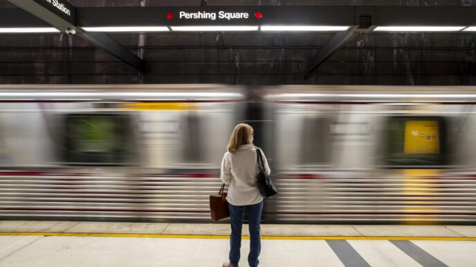 Ciudad con transporte público: Mujer espera el tren en la estación Pershing Square. Movilidad urbana en Los Ángeles, California.