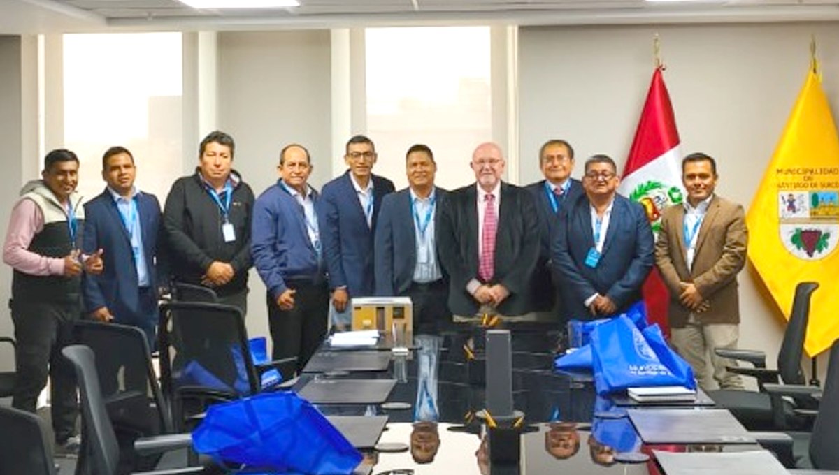 Grupo de personas posando en Inmobiliare Summits, evento real estate en LATAM. Reunión en un venue con banderas de Perú y Santiago de Surco.