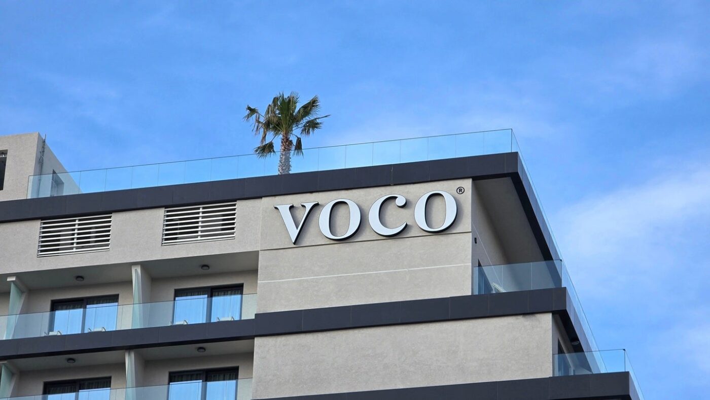 Fachada del hotel VOCO en México, parte de la expansión de Aimbridge con seis nuevos hoteles para 2026. Arquitectura moderna y cielo azul.