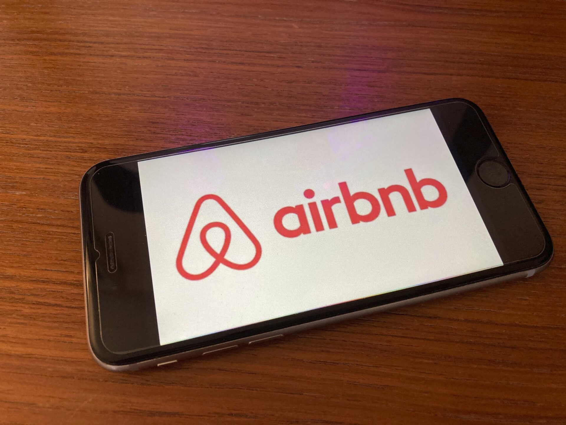 Sponsors/branding.
Teléfono muestra el logo de Airbnb, patrocinador en Inmobiliare Summits. Real estate y tecnología en conferencia LATAM, México.