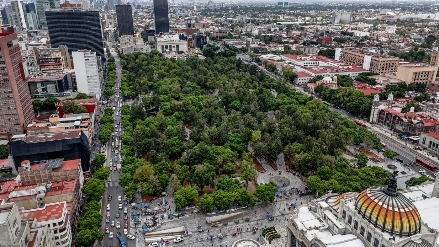 Vista aérea de la Alameda Central, un parque urbano en Ciudad de México, con edificios altos y tráfico. Un Town Center vibrante con historia y cultura.