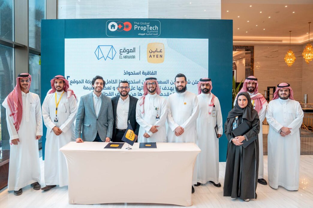 Grupo posa en evento PropTech con logos El-Mawkaa y Ayen, alianza Egipto-Saudí impulsa startups, destacando innovación inmobiliaria y tecnológica.