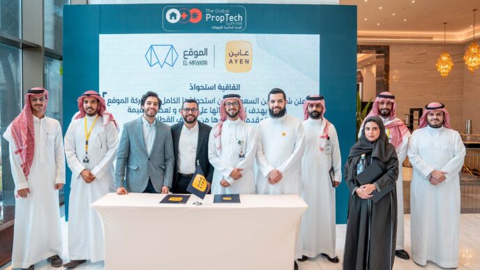 Grupo posa en evento PropTech con logos El-Mawkaa y Ayen, alianza Egipto-Saudí impulsa startups, destacando innovación inmobiliaria y tecnológica.