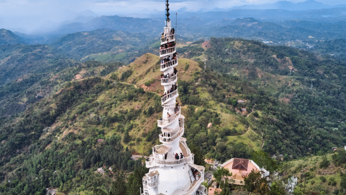 venue/architecture
Torre blanca con escalera en espiral y personas, rodeada de montañas verdes. Arquitectura única en un destino turístico.