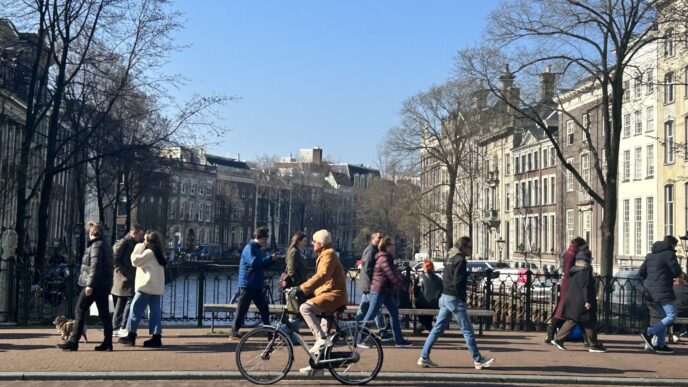 City/Destination.

Ámsterdam, destino de Inmobiliare Summits, restringe la construcción de hoteles. Vista de la ciudad con personas caminando y en bicicleta.