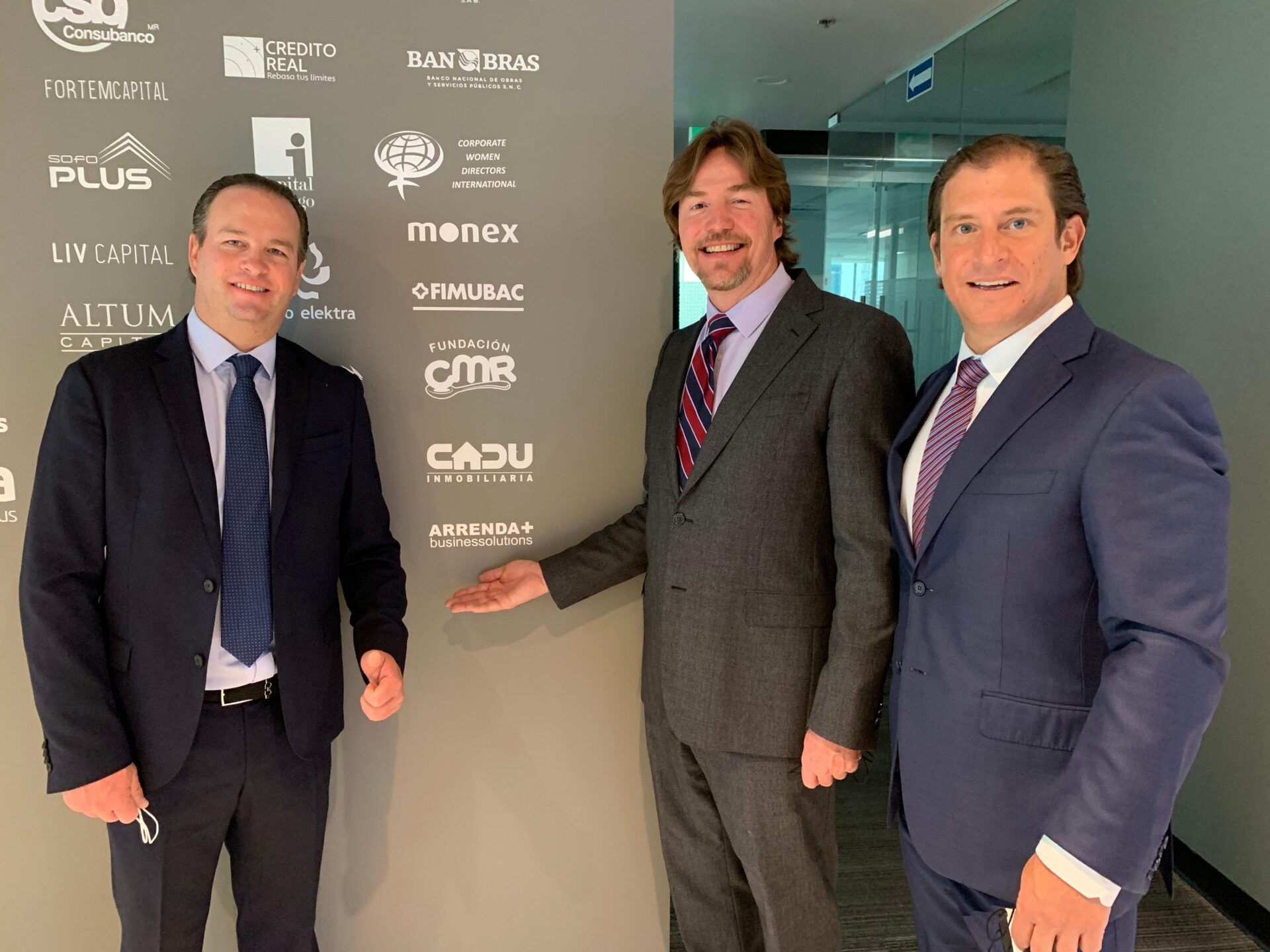 Oradores posan frente a logos de patrocinadores en Arrendamas, evento inmobiliario en México. Conferencia LATAM.