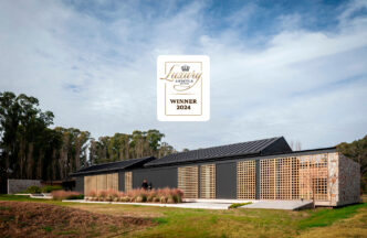 Casa Orilla, residencia de lujo ganadora 2024. Arquitectura moderna con detalles en madera y piedra. Diseño premiado de estilo contemporáneo.