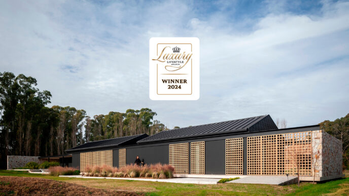 Casa Orilla, residencia de lujo ganadora 2024. Arquitectura moderna con detalles en madera y piedra. Diseño premiado de estilo contemporáneo.