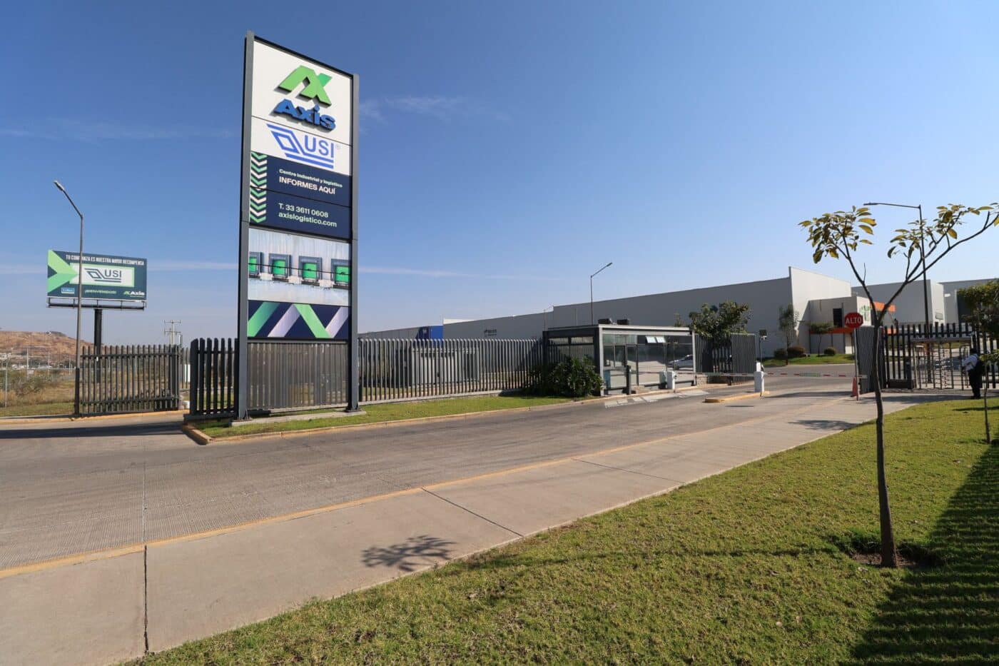 Entrada a Axis, parque industrial en Guadalajara. Señalización con logo de Axis y USI, centro industrial y logístico. Informes y acceso al parque.