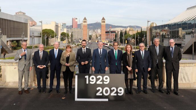 Grupo posa en Montjuïc, Barcelona, para la renovación del recinto. Inversión de 174 mde, torres gemelas al fondo. Anuncio de 1929-2029.