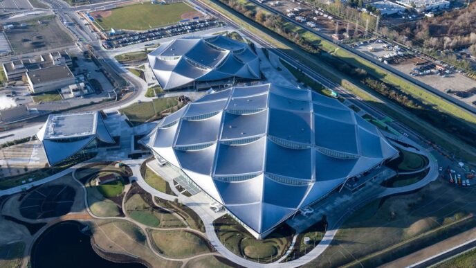 Vista aérea del nuevo campus Bay View de Google en Silicon Valley. Se ven edificios modernos con diseños geométricos y áreas verdes. Arquitectura innovadora.