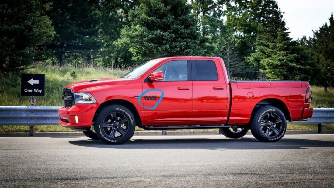 Camioneta roja Ram 1500 en Saltillo, Coahuila. Borgwarner expande operaciones con nuevo complejo. Vista lateral del vehículo en carretera con señal de tráfico.