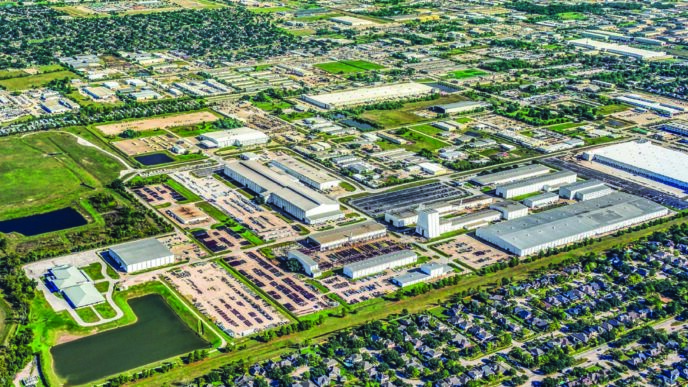 Vista aérea de la inversión de Brennan Investment Group en el mercado industrial. Naves, almacenes y zonas de carga en un parque empresarial moderno.