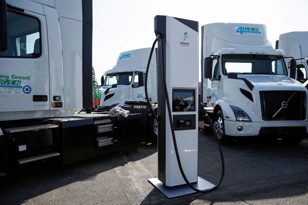Camiones eléctricos de California en estación de carga Electrify America. Liderazgo en transporte sostenible y cero emisiones. Volvo Trucks 4GEN.