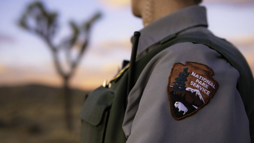 speakers/headshot

Sello del Servicio de Parques Nacionales de EE. UU. en uniforme. Preocupación por cancelación de programa y el impacto en carreteras.