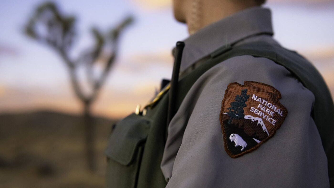 speakers/headshot

Sello del Servicio de Parques Nacionales de EE. UU. en uniforme. Preocupación por cancelación de programa y el impacto en carreteras.