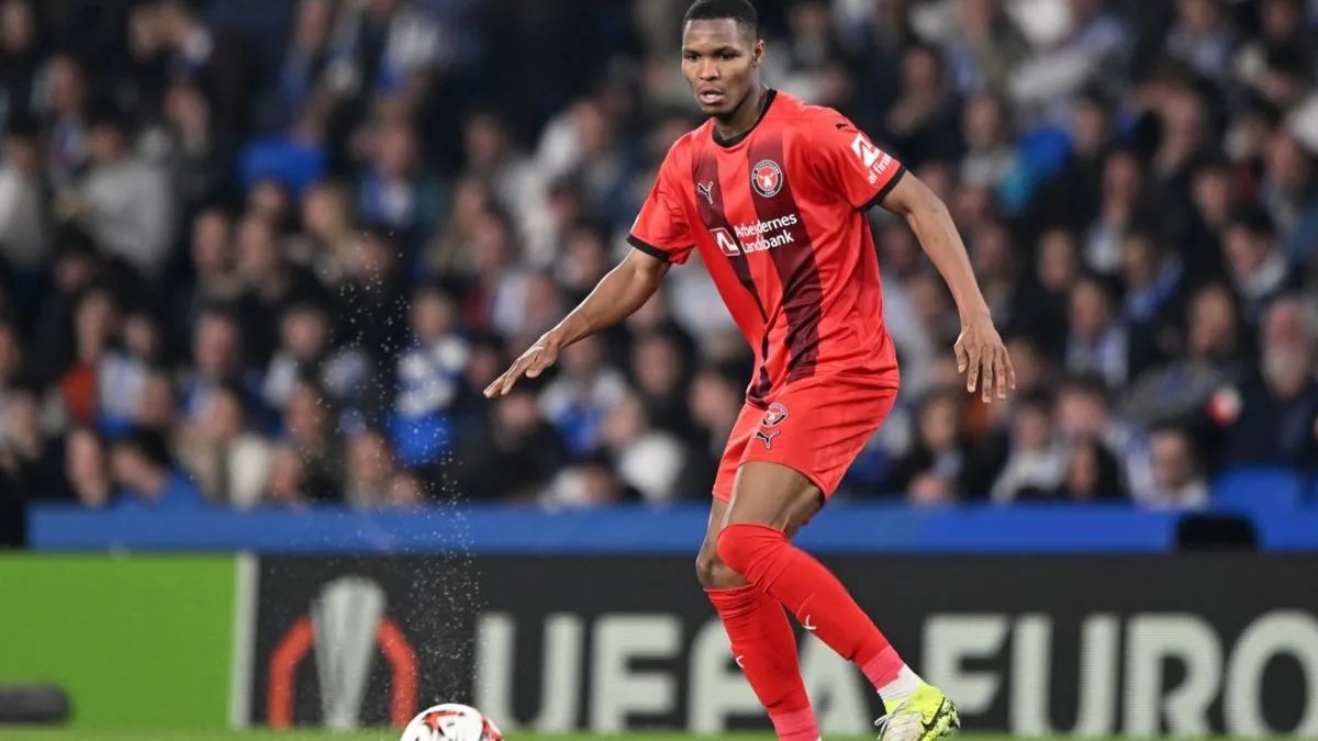 The image does not relate to the keywords provided. I will generate an alt text based on the image content.

Jugador de fútbol en acción durante un partido. El deportista viste uniforme rojo y domina el balón en el campo. Fútbol.