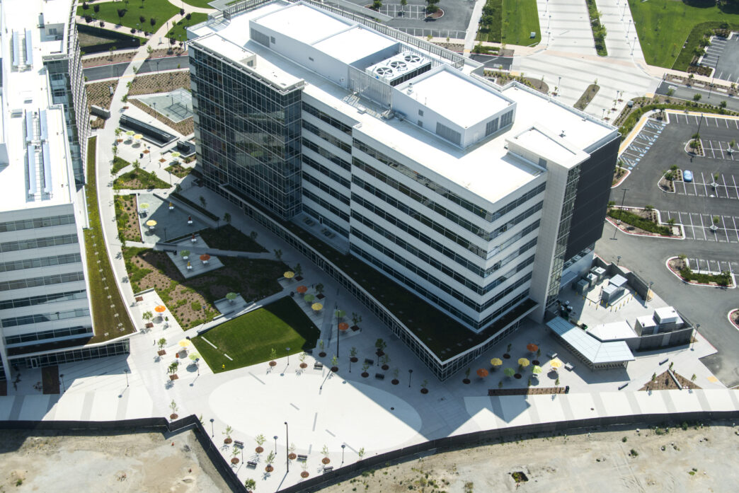 Vista aérea de edificio moderno con diseño sostenible. Caso de estudio sobre sostenibilidad en la construcción. Arquitectura eco-friendly y paisajismo urbano.