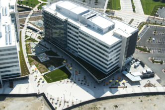 Vista aérea de edificio moderno con diseño sostenible. Caso de estudio sobre sostenibilidad en la construcción. Arquitectura eco-friendly y paisajismo urbano.