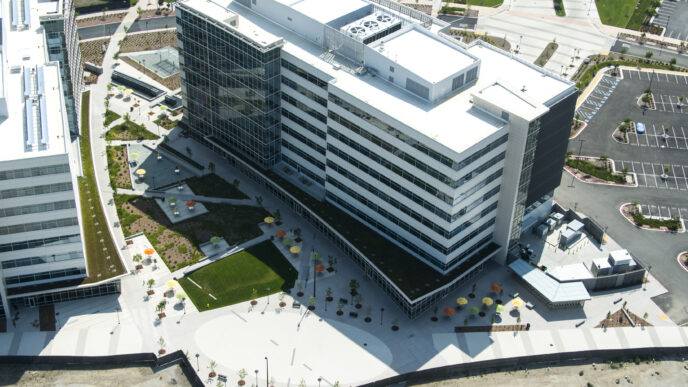 Vista aérea de edificio moderno con diseño sostenible. Caso de estudio sobre sostenibilidad en la construcción. Arquitectura eco-friendly y paisajismo urbano.