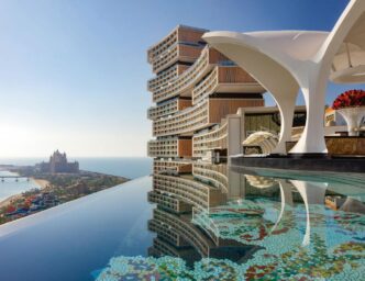 Vista aerea del lujoso Hotel Caribe Hilton, con piscina infinita y arquitectura moderna. CBRE y JLL buscan comprador para este emblemático hotel.