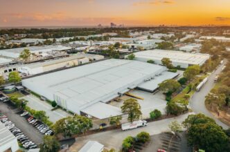 Vista aérea de un parque industrial al atardecer, mostrando el impacto del cierre del fondo industrial de BGO en el sector de Real Estate.