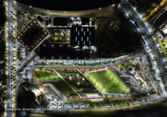 Vista aérea nocturna del Distrito TEC ITESM en Ciudad Juárez. Espacios verdes, edificios iluminados y senderos resaltan el desarrollo urbano sostenible.