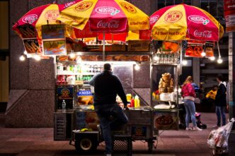 Carreta de comida en México, con sombrillas de Coca-Cola y Nikas, ofreciendo hot dogs, pretzels y knishes. Propuestas para mejorar carretas visibles.