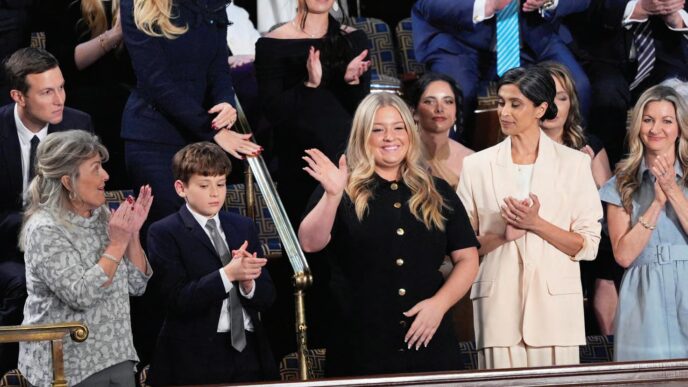 Attendees at an event, some clapping, one waving, in a formal setting. Government priorities, CMIC obras, Claudia Sheinbaum's administration.