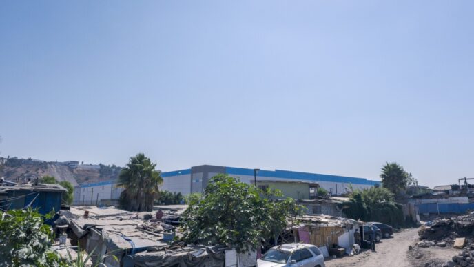 Contraste en Tijuana: Naves industriales modernas destacan junto a viviendas precarias. Oportunidad de construcción y desarrollo local en Baja California.
