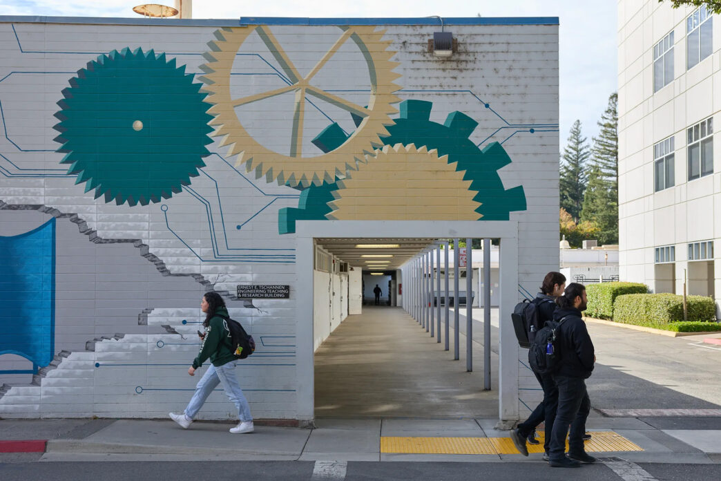 venue/architecture
Personas caminan frente a edificio con mural de engranajes. Espacio para conferencias Inmobiliare Summits. Arquitectura en México.