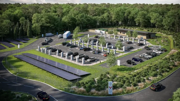 Imagen de la colaboración cleantech: coches eléctricos cargándose en estación con paneles solares, impulsando la transición verde y sostenible.