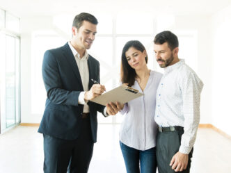 Networking/expo.

Agente inmobiliario revisa documentos con pareja en evento Inmobiliare Summits. Oportunidades de inversión en bienes raíces en México y LATAM.