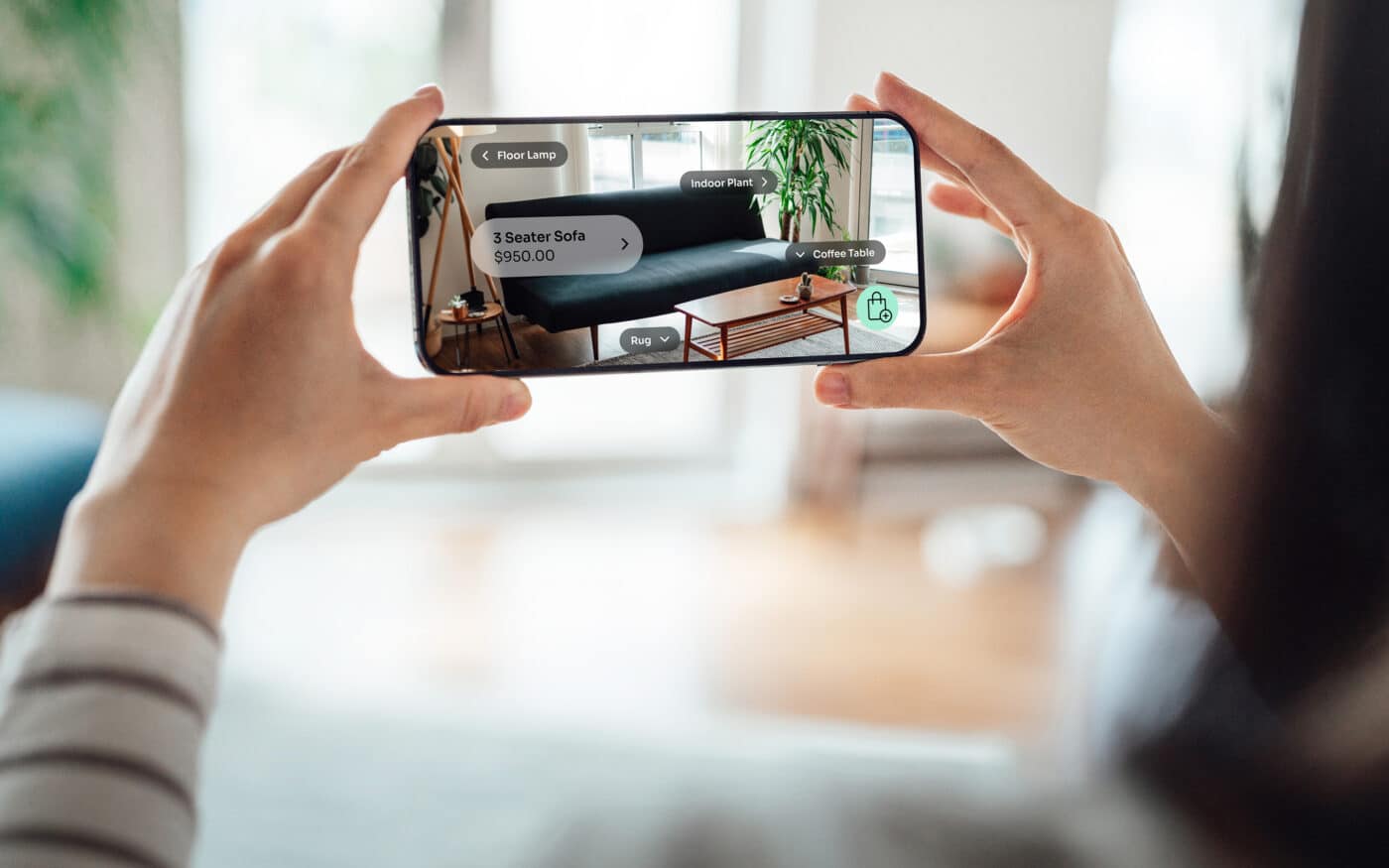 Persona usando app de comercio electrónico en móvil para visualizar sofá y muebles en 3D. Compra de muebles online, España y comercio electrónico.