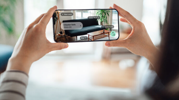 Persona usando app de comercio electrónico en móvil para visualizar sofá y muebles en 3D. Compra de muebles online, España y comercio electrónico.