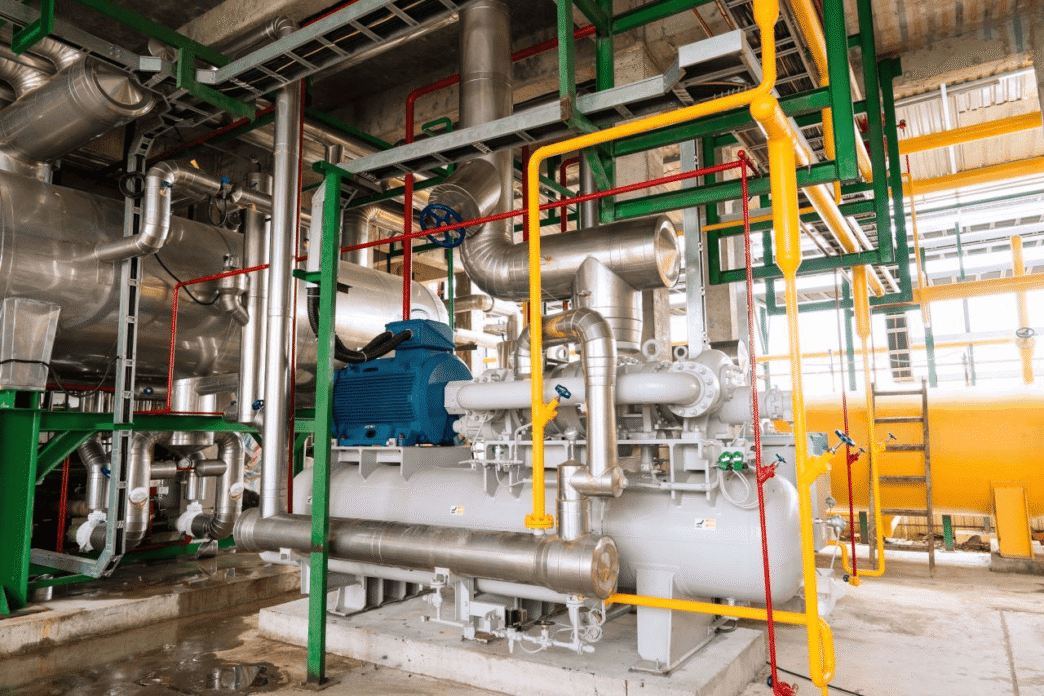 Instalación industrial con tuberías de colores y maquinaria gris. GreenYellow impulsa la eficiencia energética en Polonia con soluciones innovadoras.