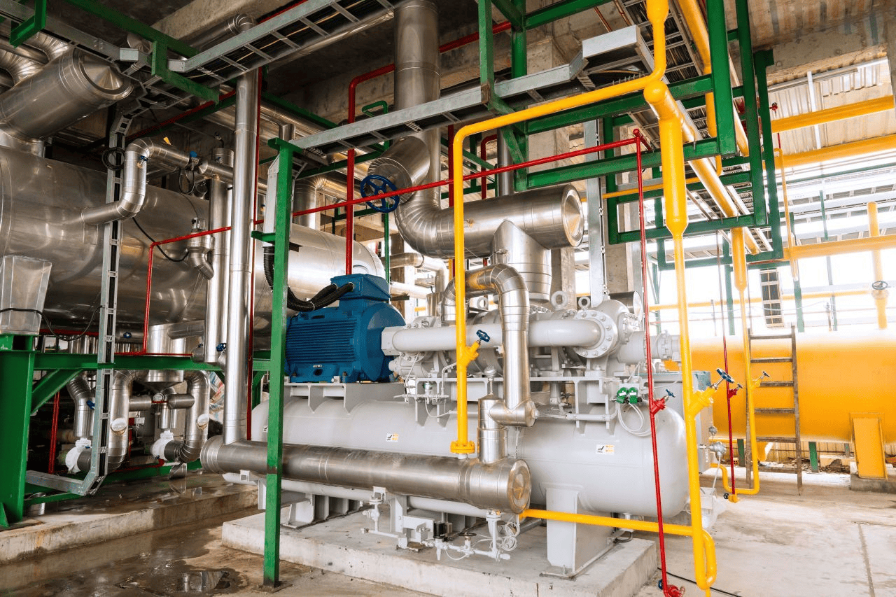 Instalación industrial con tuberías de colores y maquinaria gris. GreenYellow impulsa la eficiencia energética en Polonia con soluciones innovadoras.