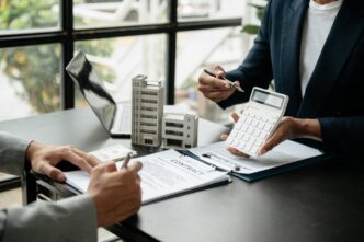 networking/expo
Asesores calculando inversión inmobiliaria en España. Contrato, calculadora y modelos de edificios en mesa. Sector inmobiliario en LATAM.