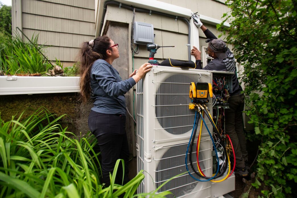 Instalación de bomba de calor en Real Estate: técnicos trabajando en la unidad exterior. Transformando la climatización con tecnología eficiente.
